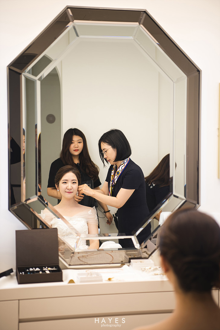 Bride choosing earrings during Korean wedding photoshoot