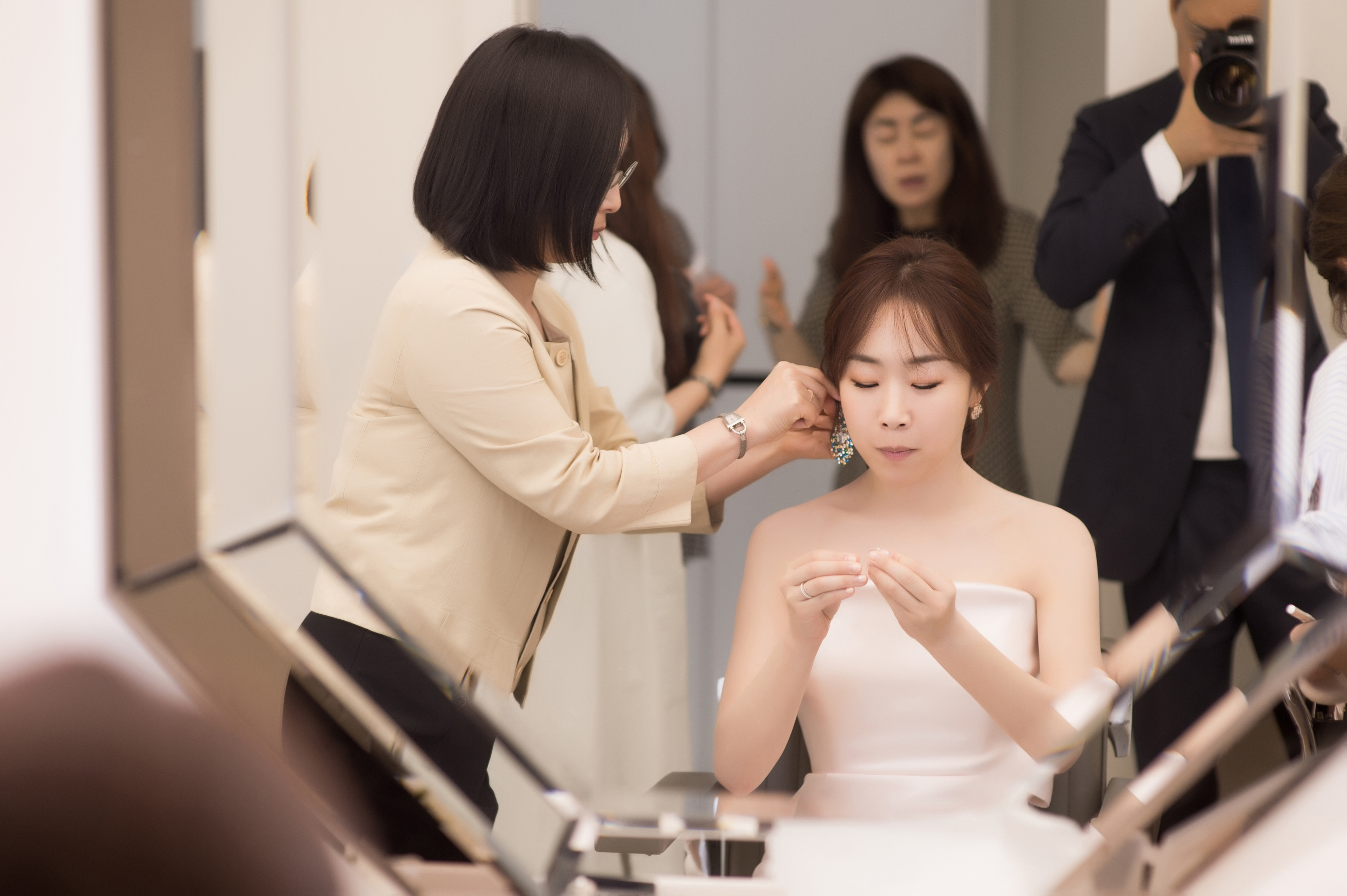 Bride choosing earrings during Korean wedding photoshoot
